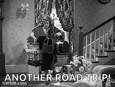 A Black And White Photo Of A Man Standing In A Living Room Holding A Bucket And A Dog . GIF