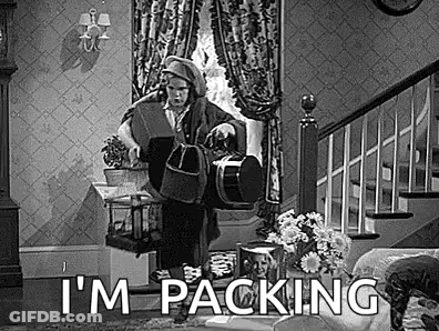 A Black And White Photo Of A Man Standing In A Living Room Holding A Bucket . GIF