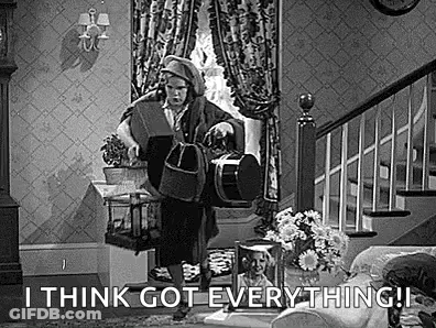 A Black And White Photo Of A Man Standing In A Living Room Holding A Drum . GIF