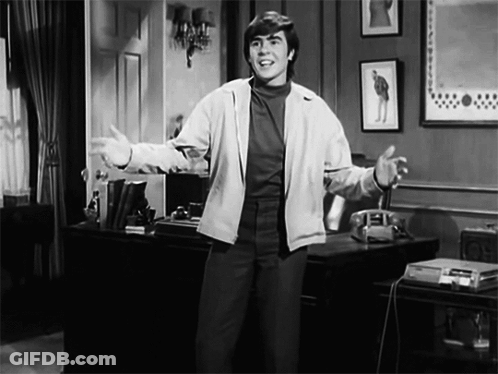 A Black And White Photo Of A Man Standing In A Room GIF