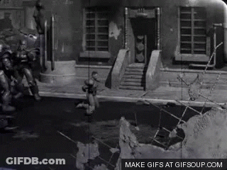 A Black And White Photo Of A Man Standing In Front Of A Building With The Words Make Gifs At Gifsoup.com Below It GIF