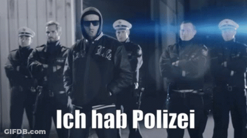 A Black And White Photo Of A Man Standing In Front Of A Group Of Police Officers With Ich Hab Polizei Written On The Bot GIF