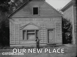 A Black And White Photo Of A Man Standing In Front Of A House With The Words `` Our New Place '' Above Him . GIF