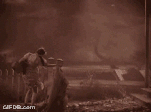 A Black And White Photo Of A Man Standing In The Dark GIF