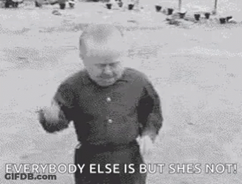 A Black And White Photo Of A Man Standing In The Dirt With The Words `` Everybody Else Is But She 'S Not '' . GIF