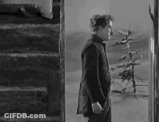 A Black And White Photo Of A Man Standing On Stairs . GIF