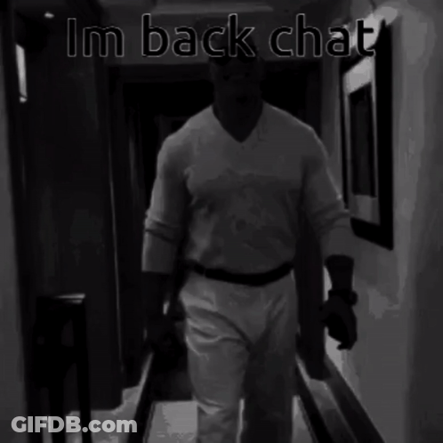A Black And White Photo Of A Man Walking Down A Hallway With The Words Im Back Chat Above Him GIF