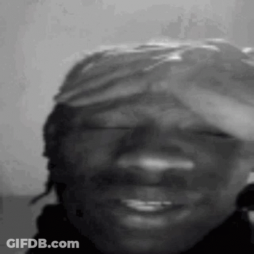 A Black And White Photo Of A Man Wearing A Bandana On His Head . GIF