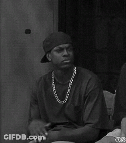 A Black And White Photo Of A Man Wearing A Baseball Cap And A Chain . GIF