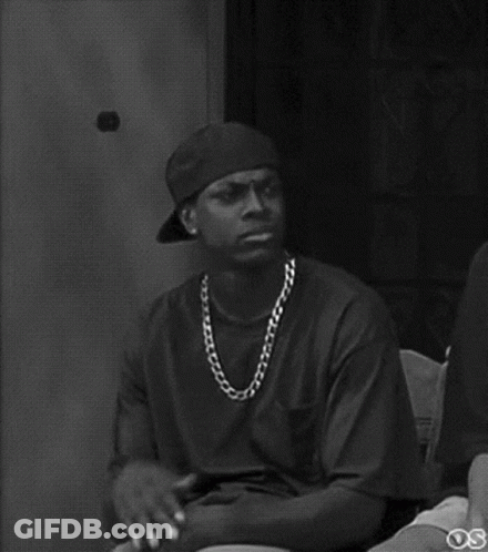 A Black And White Photo Of A Man Wearing A Baseball Cap And Chain . GIF