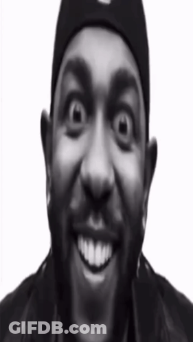 A Black And White Photo Of A Man Wearing A Beanie And Smiling GIF
