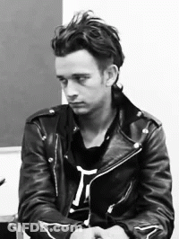 A Black And White Photo Of A Man Wearing A Black Leather Jacket GIF