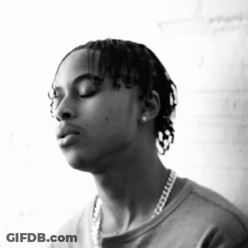 A Black And White Photo Of A Man Wearing A Chain Around His Neck GIF