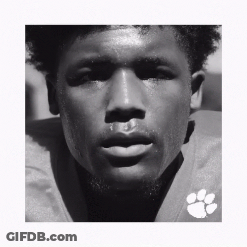 A Black And White Photo Of A Man Wearing A Clemson Football Uniform GIF