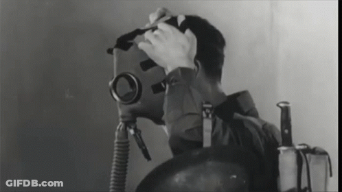 A Black And White Photo Of A Man Wearing A Gas Mask And A Knife GIF