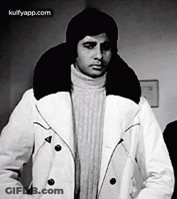 A Black And White Photo Of A Man Wearing A Hat And A White Coat . GIF