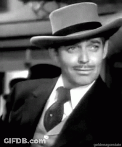 A Black And White Photo Of A Man Wearing A Hat And Tie GIF