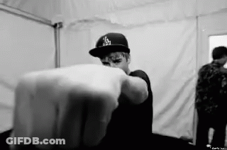 A Black And White Photo Of A Man Wearing A Hat Pointing His Finger At The Camera . GIF