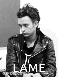A Black And White Photo Of A Man Wearing A Leather Jacket And A Black Shirt . GIF