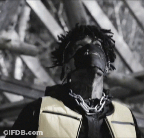 A Black And White Photo Of A Man Wearing A Mask And A Yellow Vest . GIF