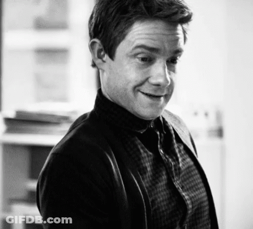 A Black And White Photo Of A Man Wearing A Plaid Shirt And Cardigan GIF
