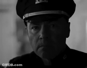 A Black And White Photo Of A Man Wearing A Police Hat . GIF