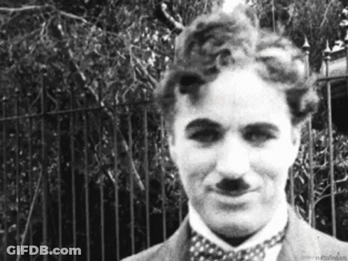 A Black And White Photo Of A Man Wearing A Suit And Bow Tie . GIF