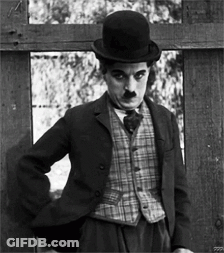 A Black And White Photo Of A Man Wearing A Suit And Top Hat GIF