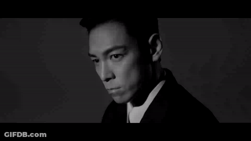 A Black And White Photo Of A Man Wearing A Suit GIF