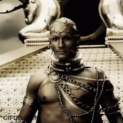 A Black And White Photo Of A Man Wearing A Very Elaborate Costume GIF