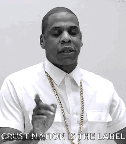 A Black And White Photo Of A Man Wearing A White Shirt And Gold Chain Pointing At The Camera . GIF