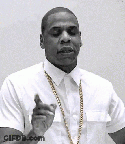 A Black And White Photo Of A Man Wearing A White Shirt And Gold Chain . GIF