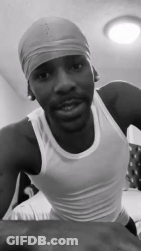 A Black And White Photo Of A Man Wearing A White Tank Top And A Headband GIF