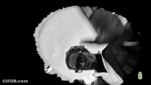 A Black And White Photo Of A Man Wearing Glasses And A Brazil Shirt GIF