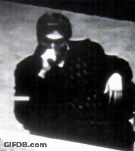 A Black And White Photo Of A Man Wearing Glasses GIF