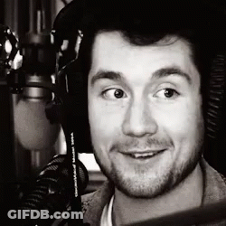 A Black And White Photo Of A Man Wearing Headphones And A Microphone GIF