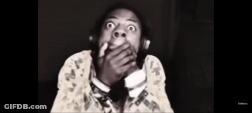 A Black And White Photo Of A Man Wearing Headphones And Covering His Mouth . GIF