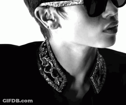 A Black And White Photo Of A Man Wearing Sunglasses And Earrings GIF