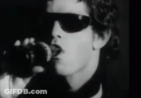 A Black And White Photo Of A Man Wearing Sunglasses And Holding A Coca Cola Bottle GIF