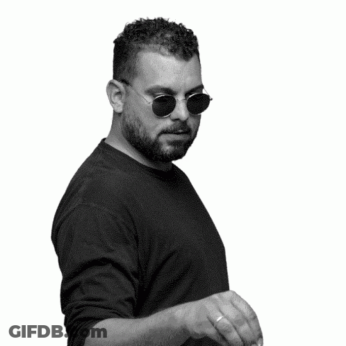 A Black And White Photo Of A Man Wearing Sunglasses And Waving His Hand GIF