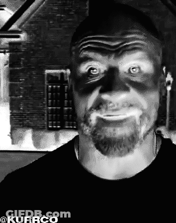 A Black And White Photo Of A Man With A Beard And A Shadow On His Face Taken By Kurrco GIF