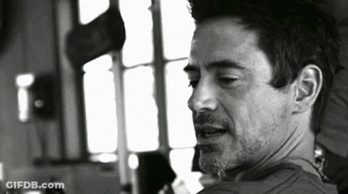 A Black And White Photo Of A Man With A Beard Looking At The Camera . GIF