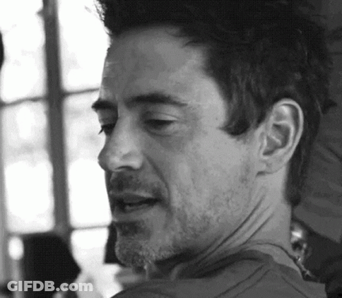 A Black And White Photo Of A Man With A Beard Looking At The Camera . GIF