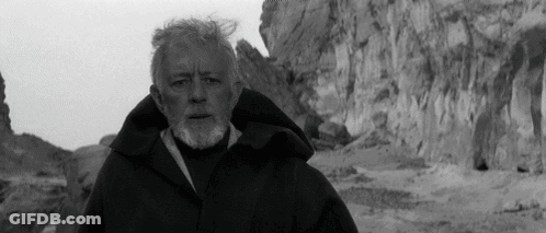 A Black And White Photo Of A Man With A Beard Standing In Front Of A Mountain GIF