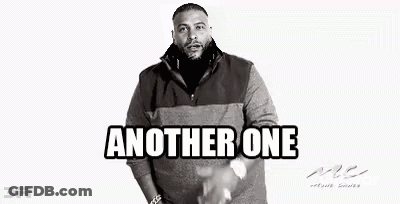 A Black And White Photo Of A Man With A Beard Wearing A Sweater And Standing With His Hands In His Pockets . GIF