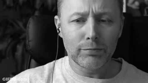 A Black And White Photo Of A Man With A Beard Wearing Headphones . GIF