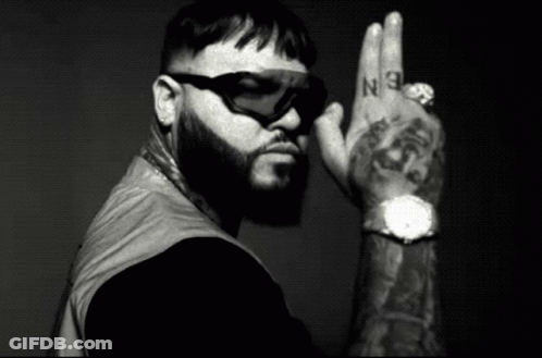 A Black And White Photo Of A Man With A Beard Wearing Sunglasses And A Watch GIF