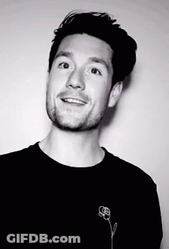 A Black And White Photo Of A Man With A Flower On His Shirt GIF