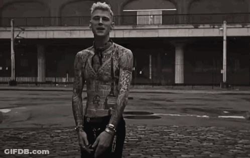 A Black And White Photo Of A Man With A Lot Of Tattoos On His Body GIF