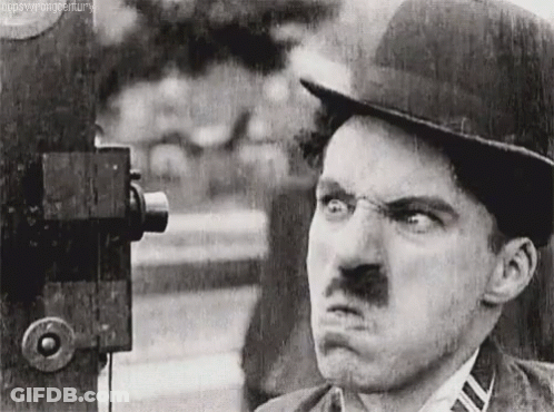 A Black And White Photo Of A Man With A Mustache Making A Funny Face GIF